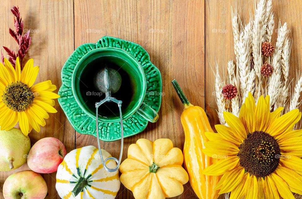 Autumnal flat lay with gourds, wheat, sunflowers and tea