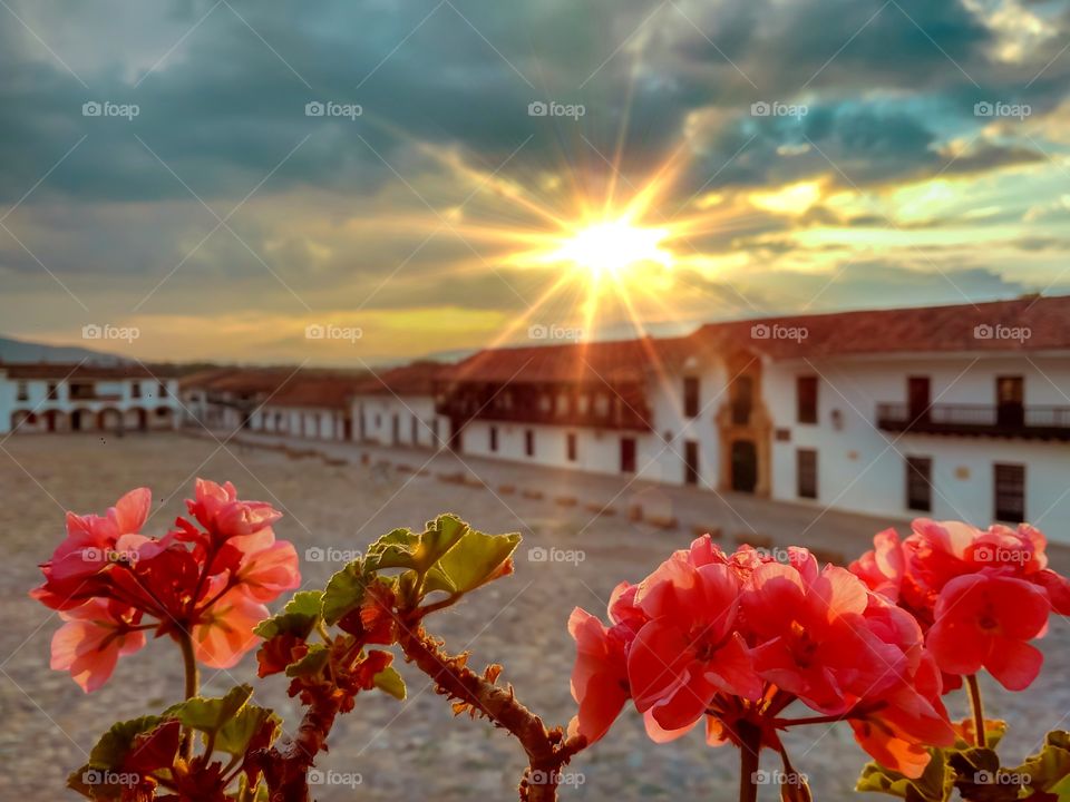 Sun rays at sunset with flowers in the main square of Villa de Leyva