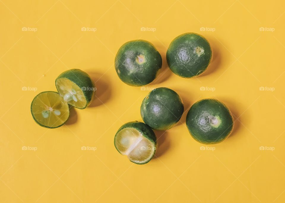 High angle view of citrus fruits on yellow background
