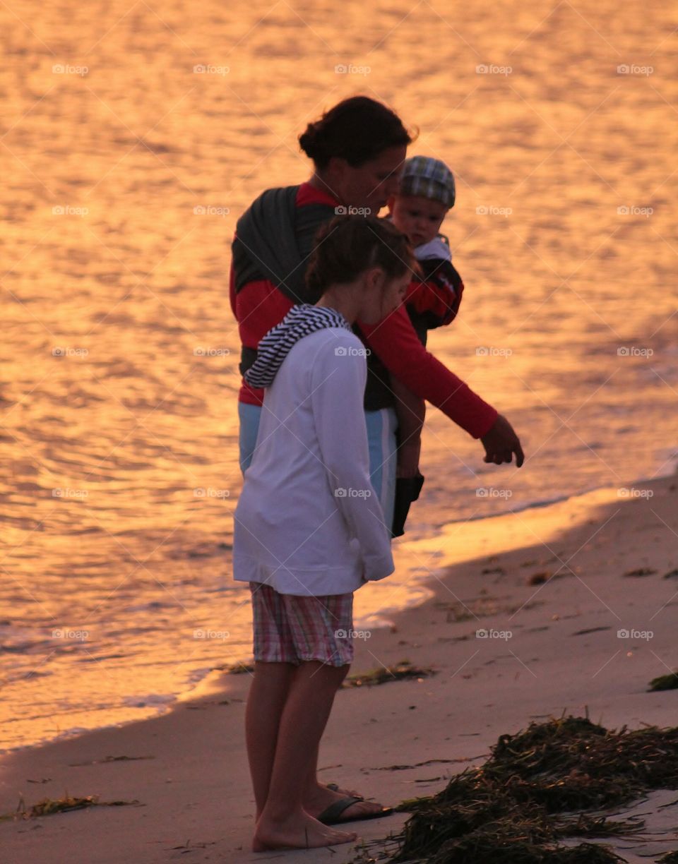 Quiet moment . Enjoying the beach at sunset,  my daughter, sister and nephew find something in the sand - hanging at the beach mission