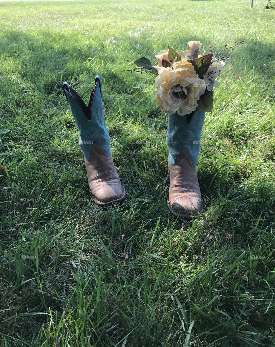A bridesmaid takes a break from pictures and places her flowers in her boots. Inadvertently creating a stunning memory. 