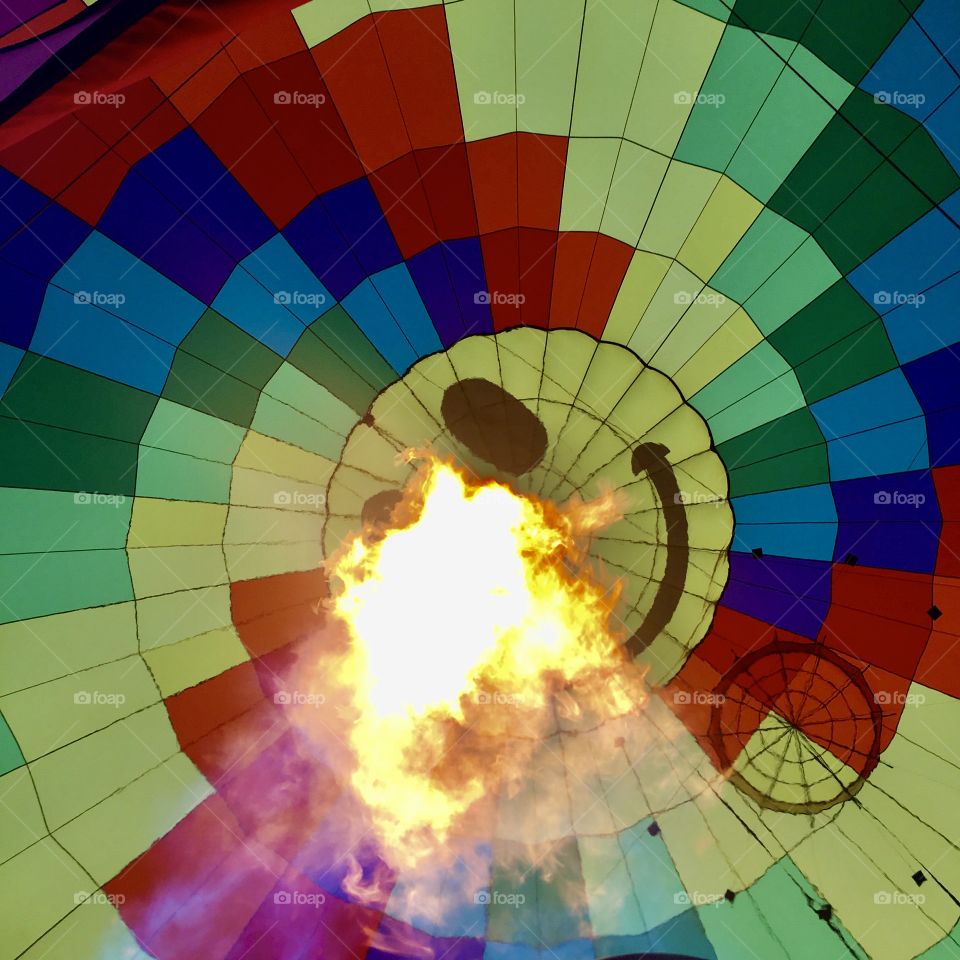 Looking up inside the envelope of a hot air balloon, as the pilot fires up the burner.  Palm Springs, CA 2016