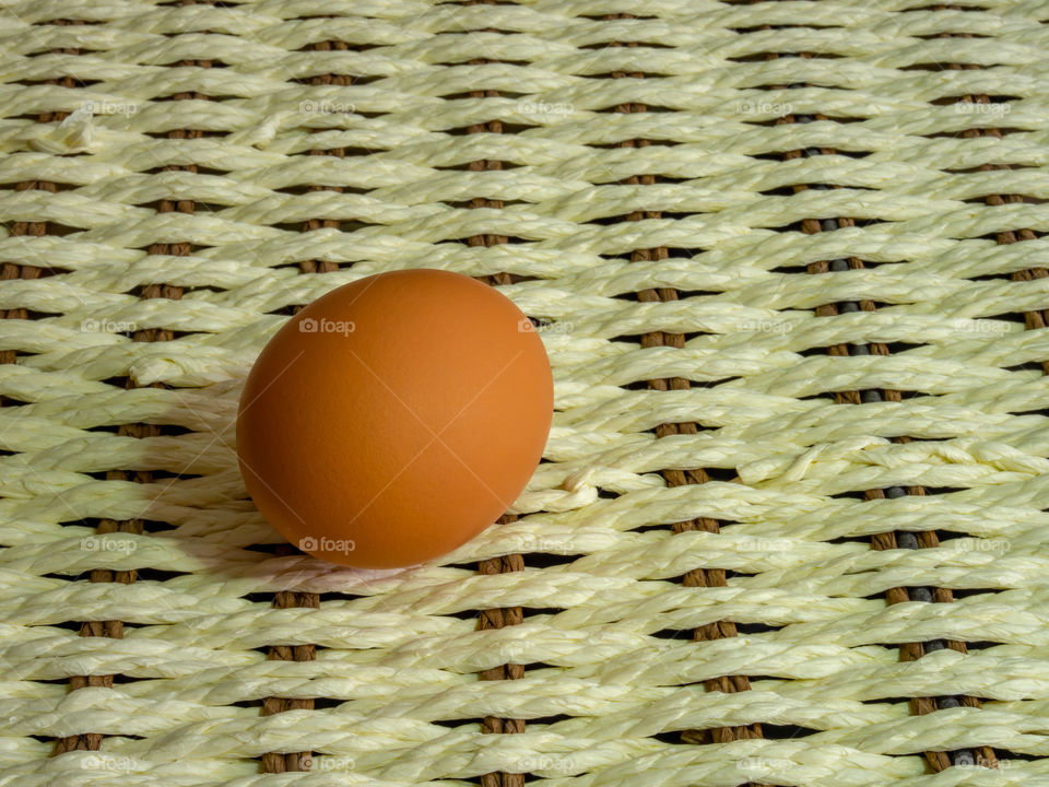 Brown eggs of light color prepare for the holiday Easter against the background from a white rope and dark branches of a tree