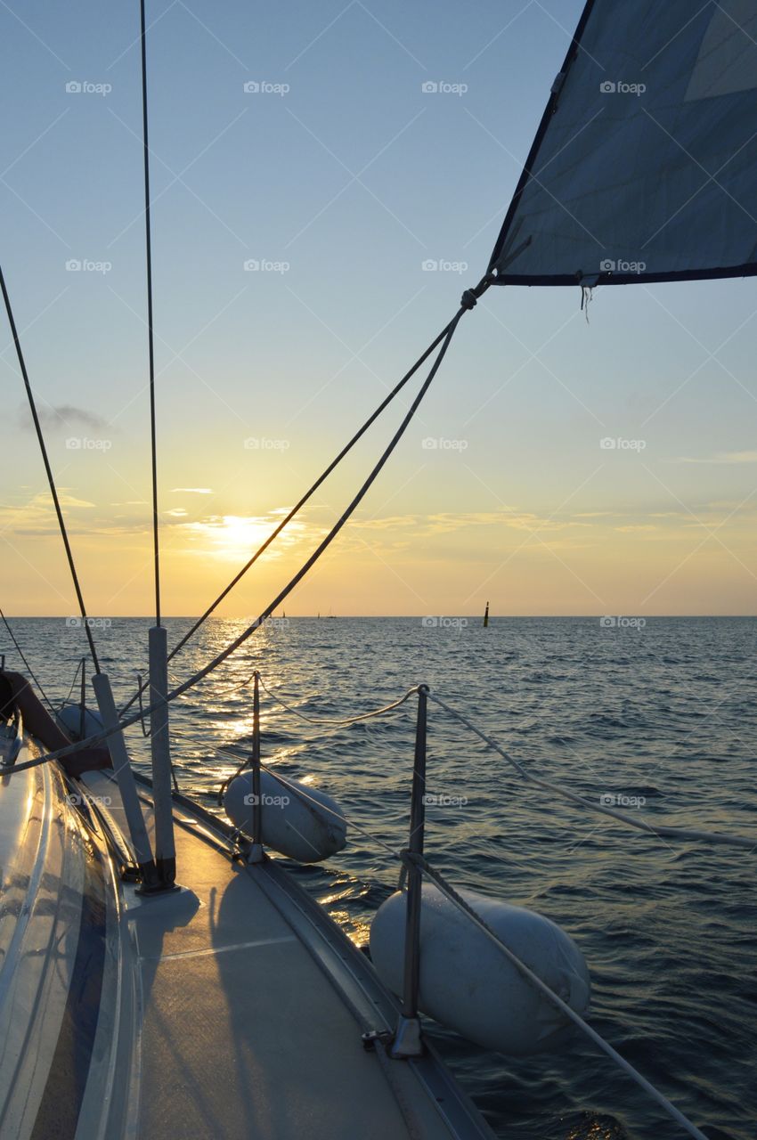 at the stern of a yacht in the sea at sunset