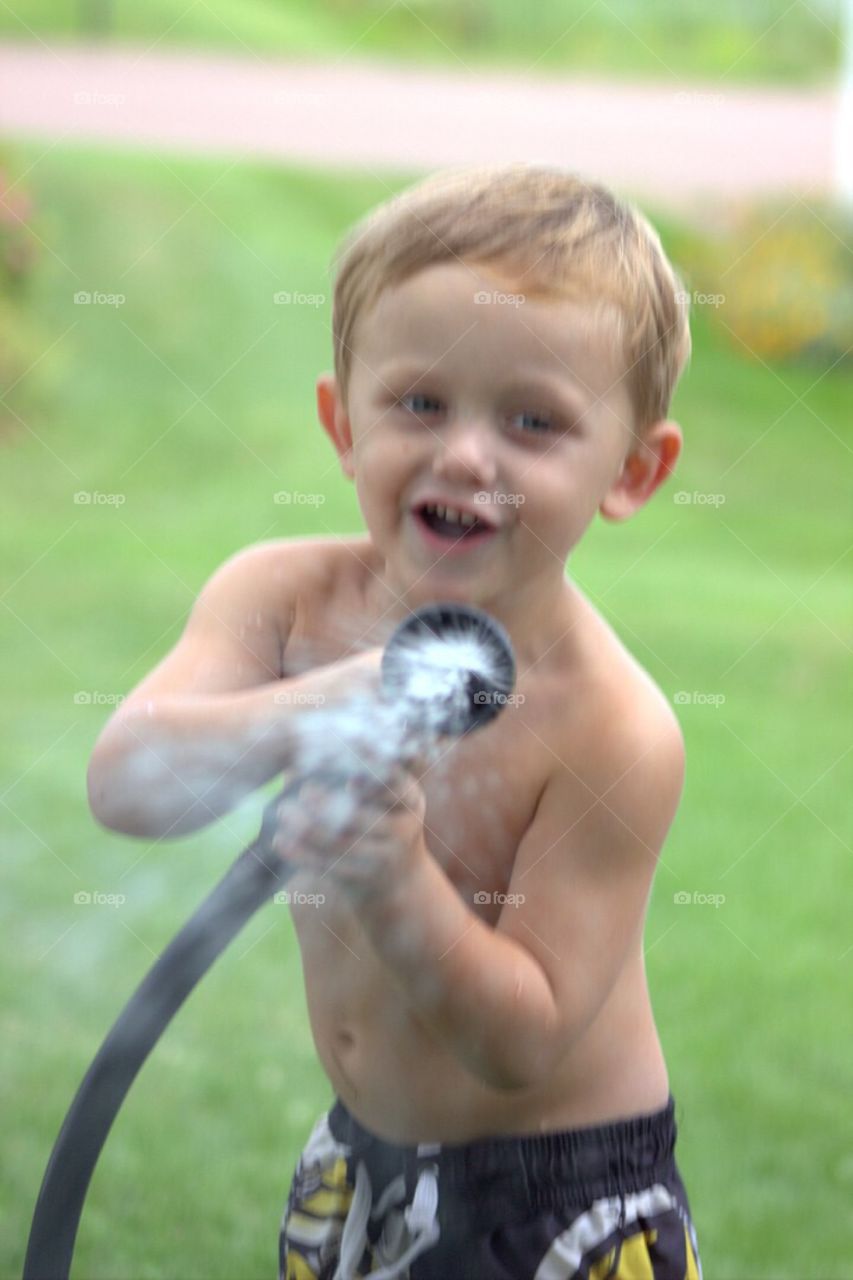 Portrait of a boy playing with hose