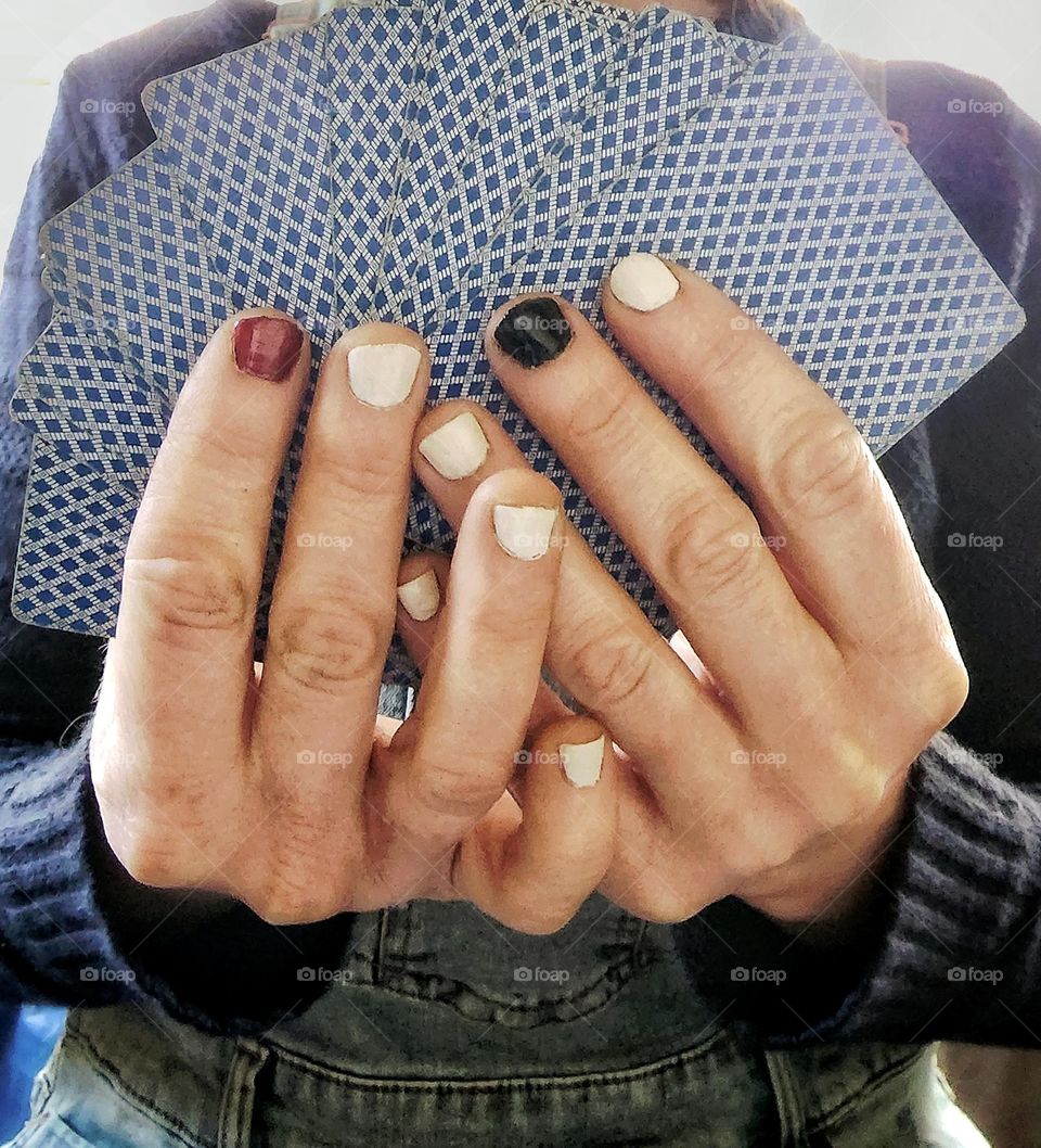 White manicure with one red nail and one black nail to represent the different suit colours in cards.
