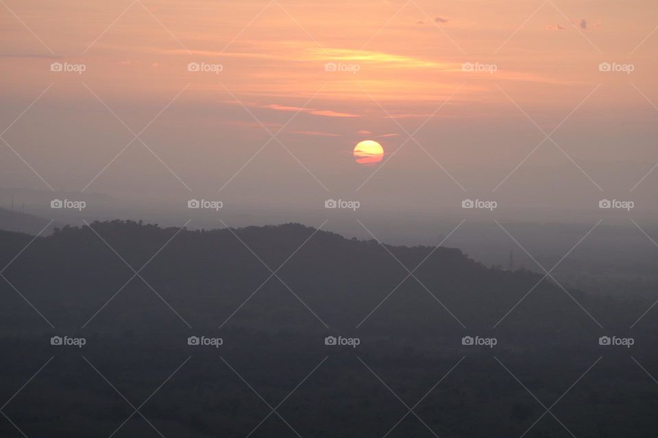 Beautiful sun rising through the hills and clouds view at a high altitude 