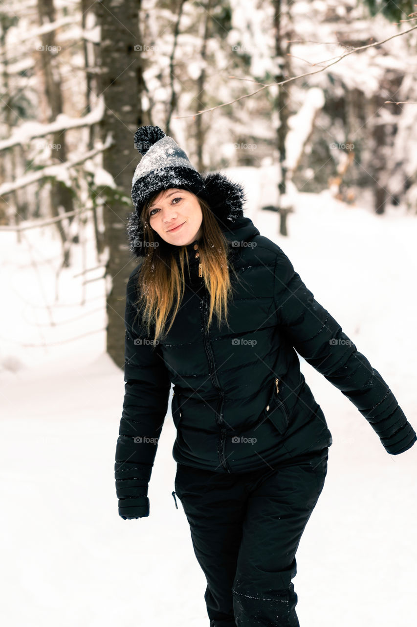 Young attractive female having fun outside in a snow covered winter wonderland scene. 