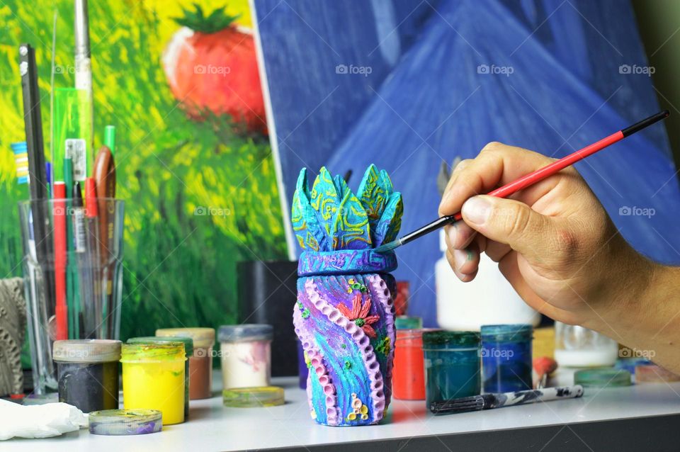 my home workshop for pouring and painting ceramic and earthenware jugs. The photo shows a jug being painted with acrylic.