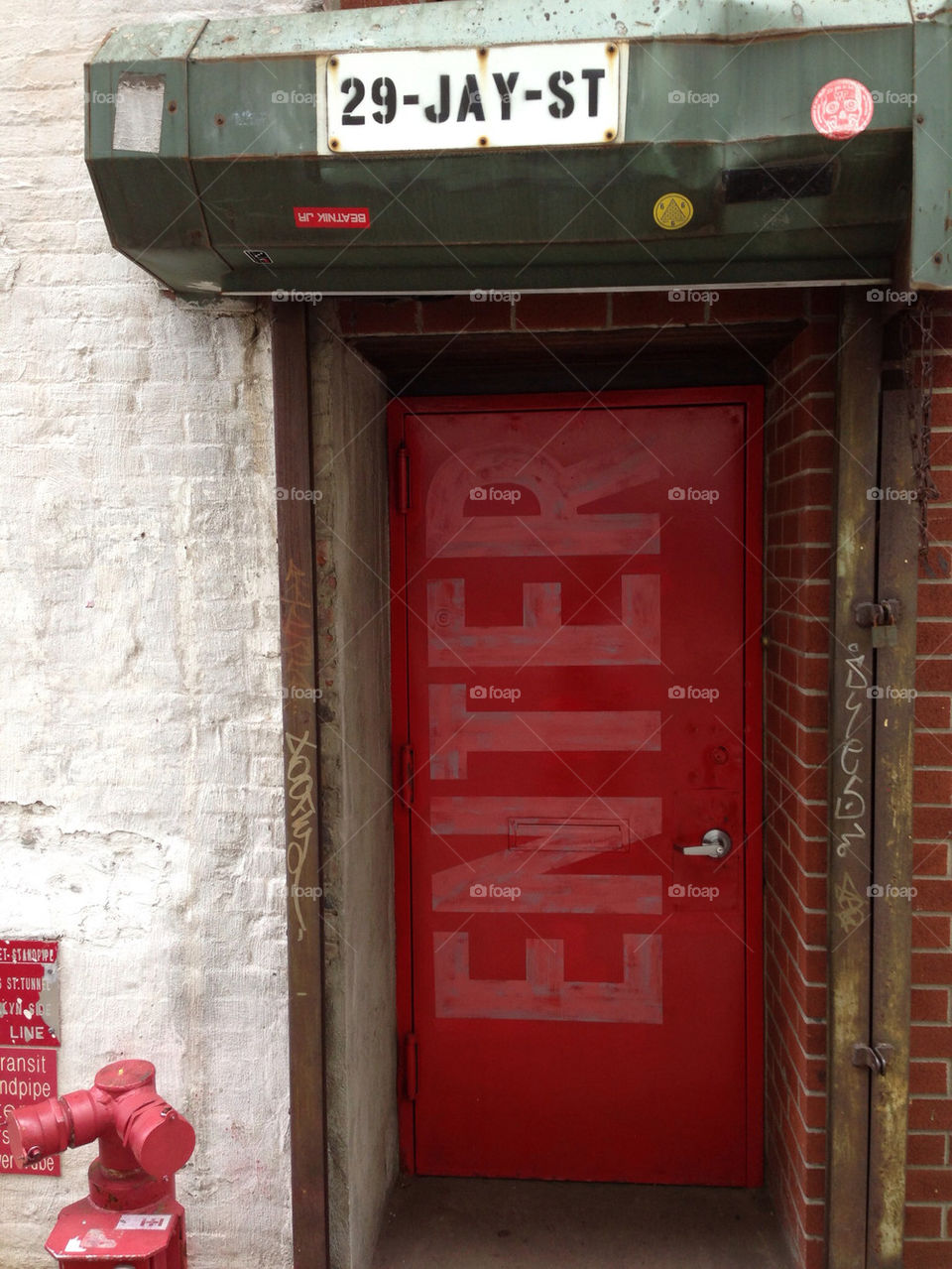 Red storefront door with "enter" stenciled on front.