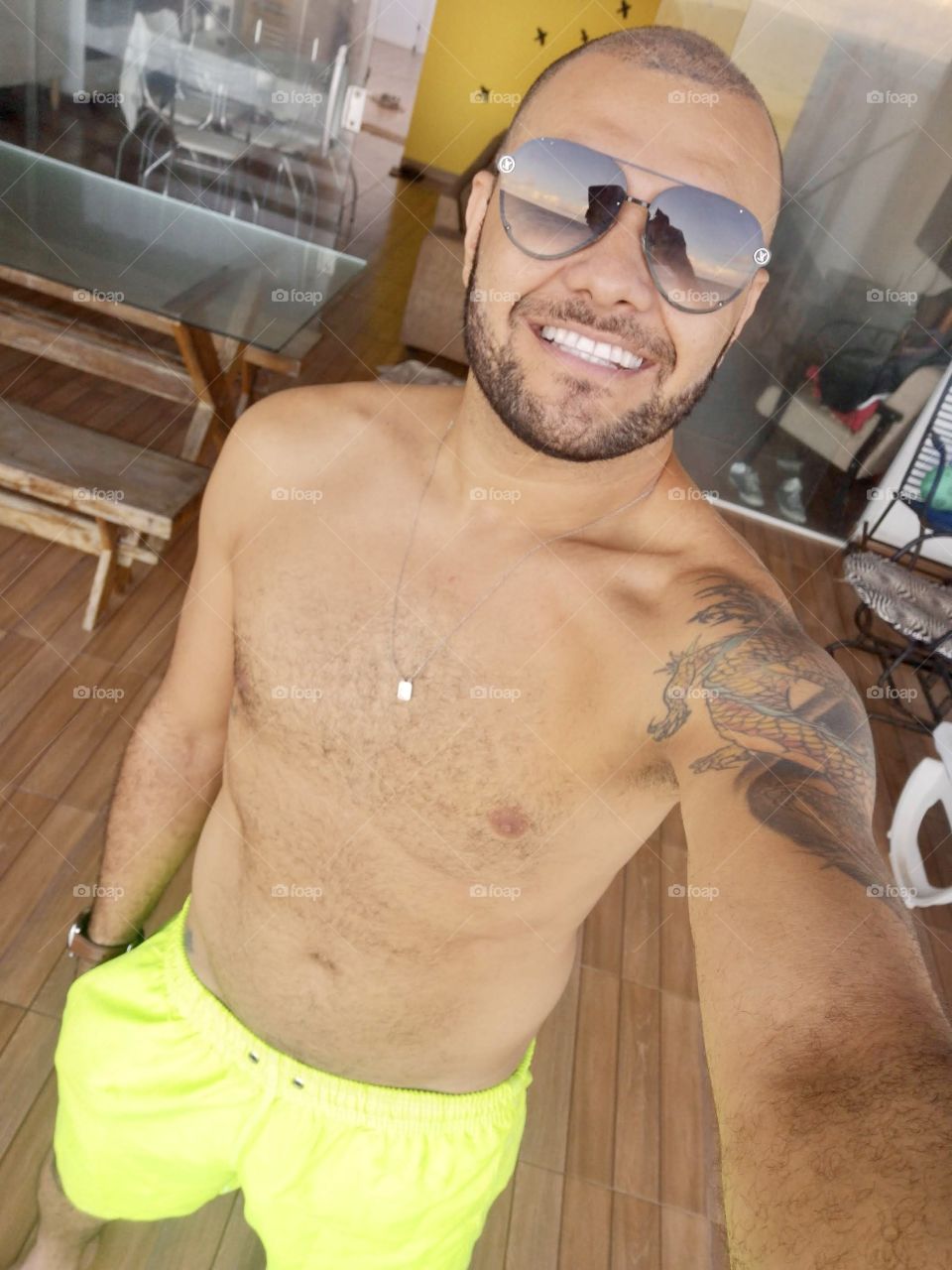Shirtless man and sunglasses smiling in selfie