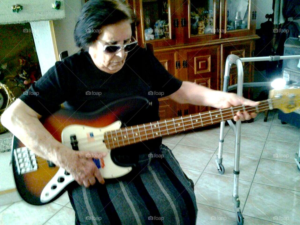 Grandma rocking around. 
She is 84 years old and was a bit down because she was missing Lody, the beloved family dog who had passed away some months before. So her son let her play his bass, to cheer her up. Just like him, she loves rock and motorbikes. Cool granny! :)