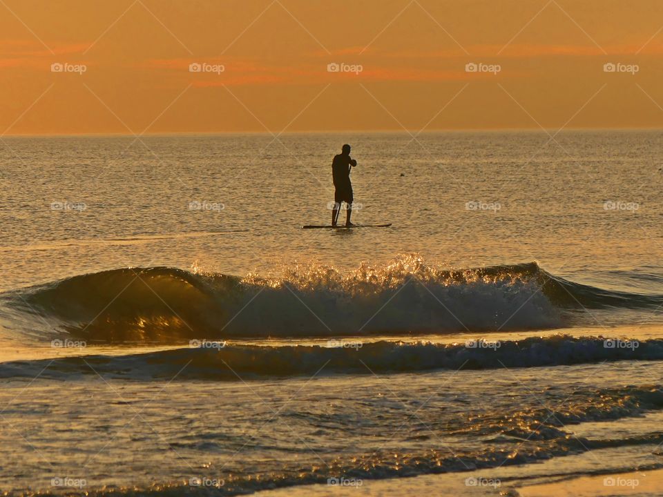 Man paddle boarding in the bay - Silhouettes are a wonderful way to convey drama, mystery, ... The perfect light for this is placing your subject in front of a sunset or sunrise – but really any bright light will be.