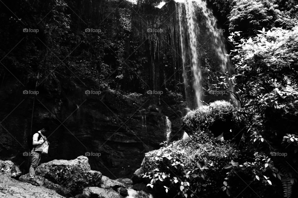 man under waterfall in bw (art image)