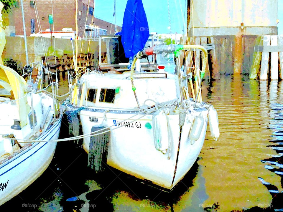 A neighboring sailboat in the waters of Newtown Creek in Long Island City, Queens, NY can be seen from ours as the rays of the evening sun cast golden reflections on the ocean. This picture was taken in the Spring of 2018. Hypnotic Productions