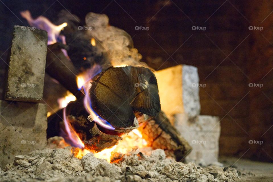 piece of wood burning in the fireplace