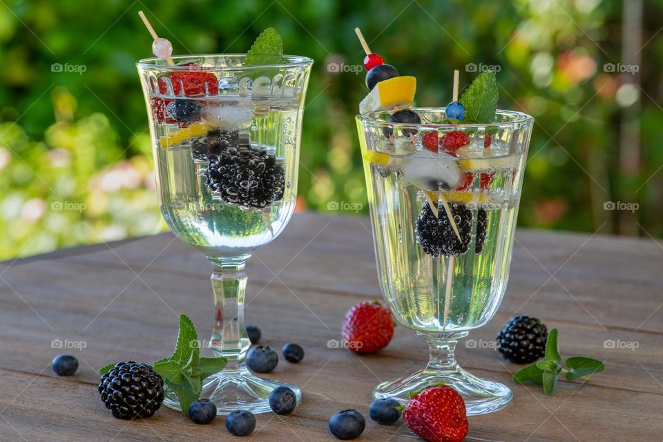 water and fruits in glasses