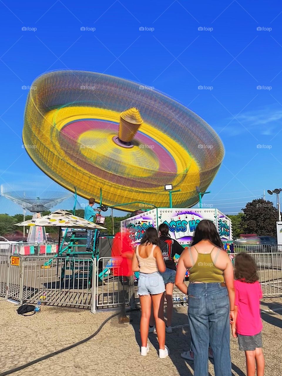 Amusement ride at the county fairgrounds, summertime fun in the United States, waiting in line for an amusement park ride, carnival rides at the county fair, fun activities in the summertime, people in line for a carnival ride, slow motion photo