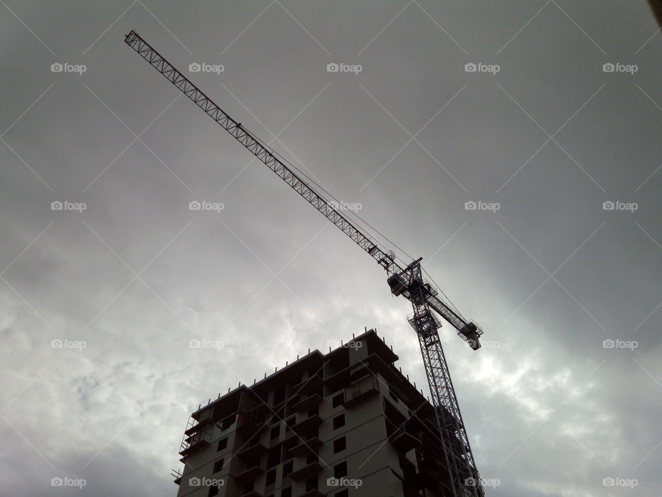 Crane on the background of a gloomy gray sky