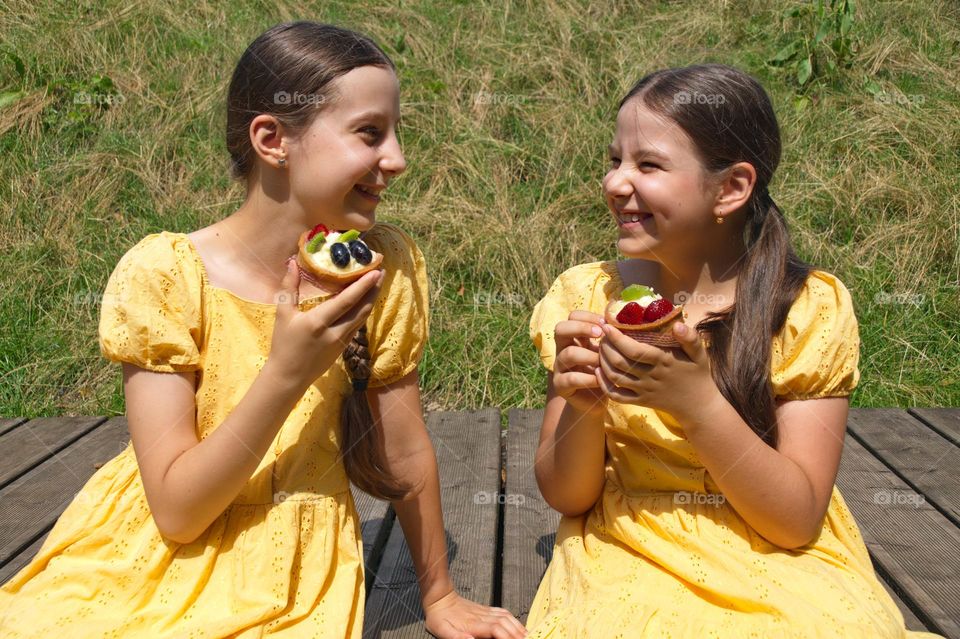 Two laughing girls with cakes