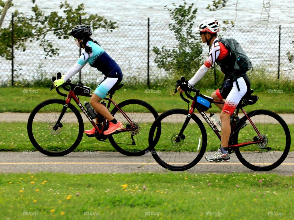 Lovers biking by river