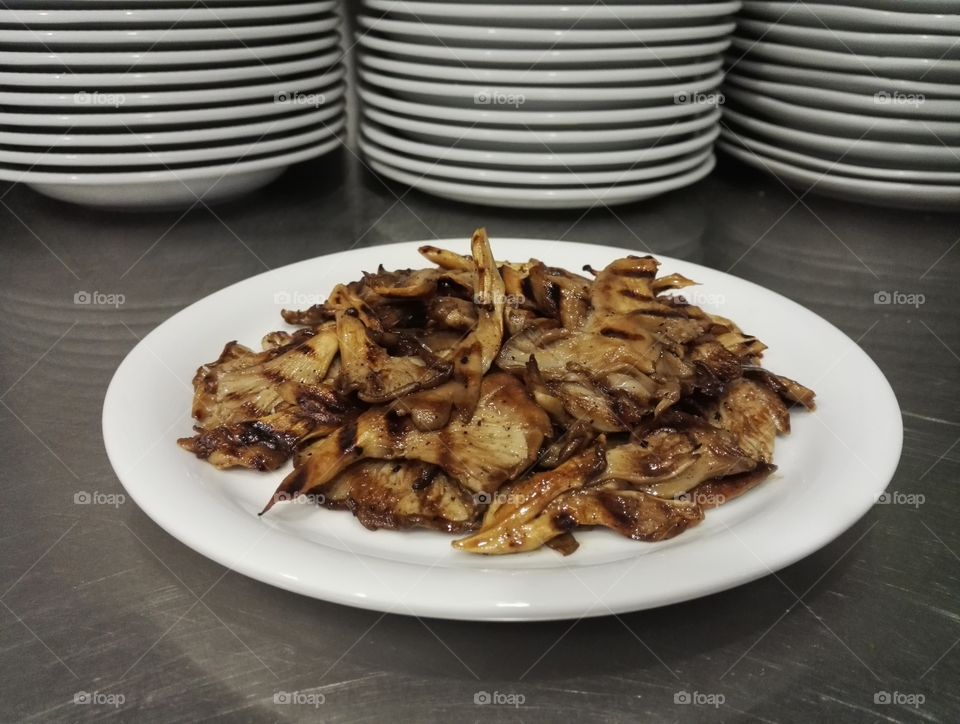 fresh grilled mushrooms on plate many plates in background