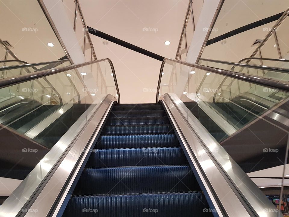 Elevator in a large bookstore, Bandung, Indonesia, escalator bounded by railings and glass, in four floor bookstore,