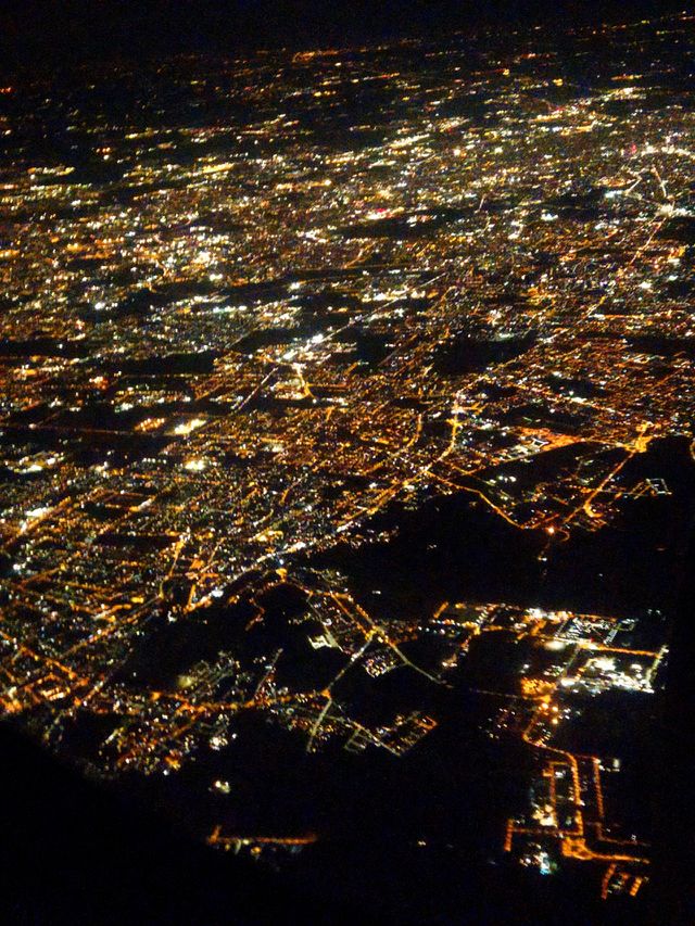 Evening.  Flight in an airplane.  Lights of Milan.  Milan through the porthole at a bird's eye view