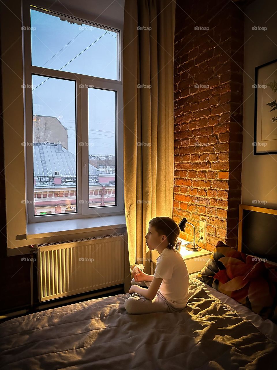 red-haired boy watching a movie in the evening at home