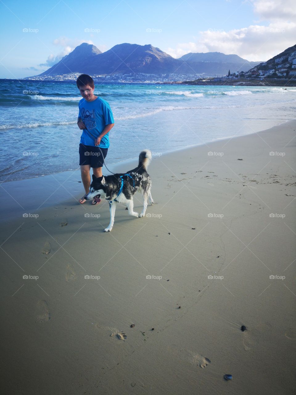 Teen walking his husky dog