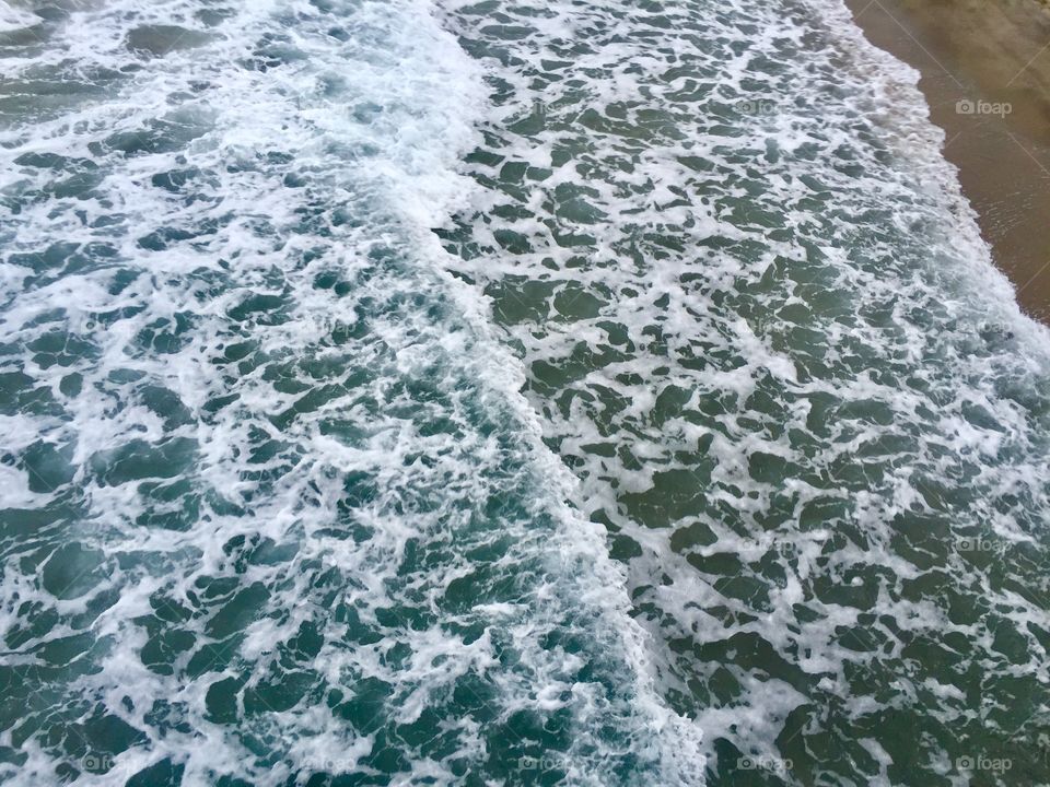 Foaming water waves ocean top view