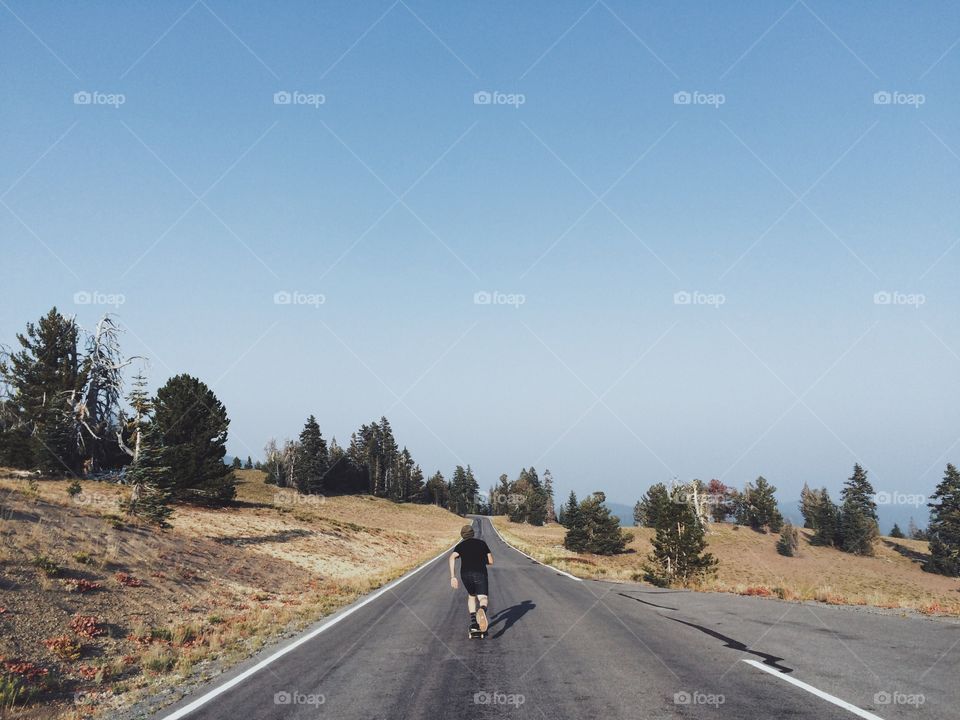Skater on the mountain road. Skateboarder skating down the mountain road in Oregon
