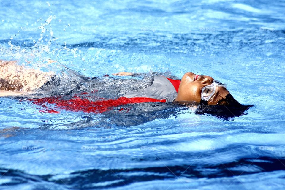 boy floating on his back in a swimming pool