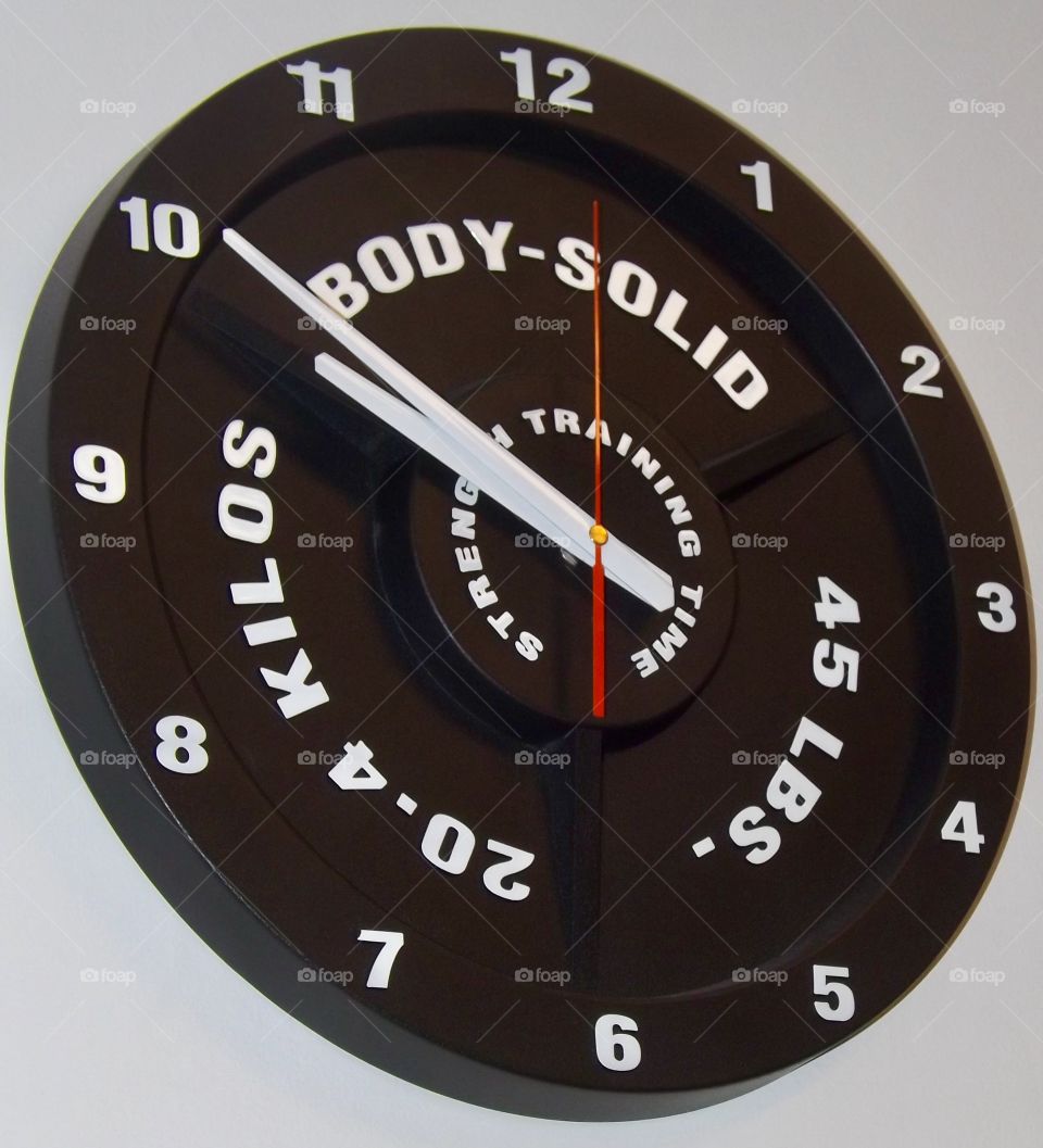 Mounted clock in a local gym. Weightlifting theme, with bold colours and numbers. 