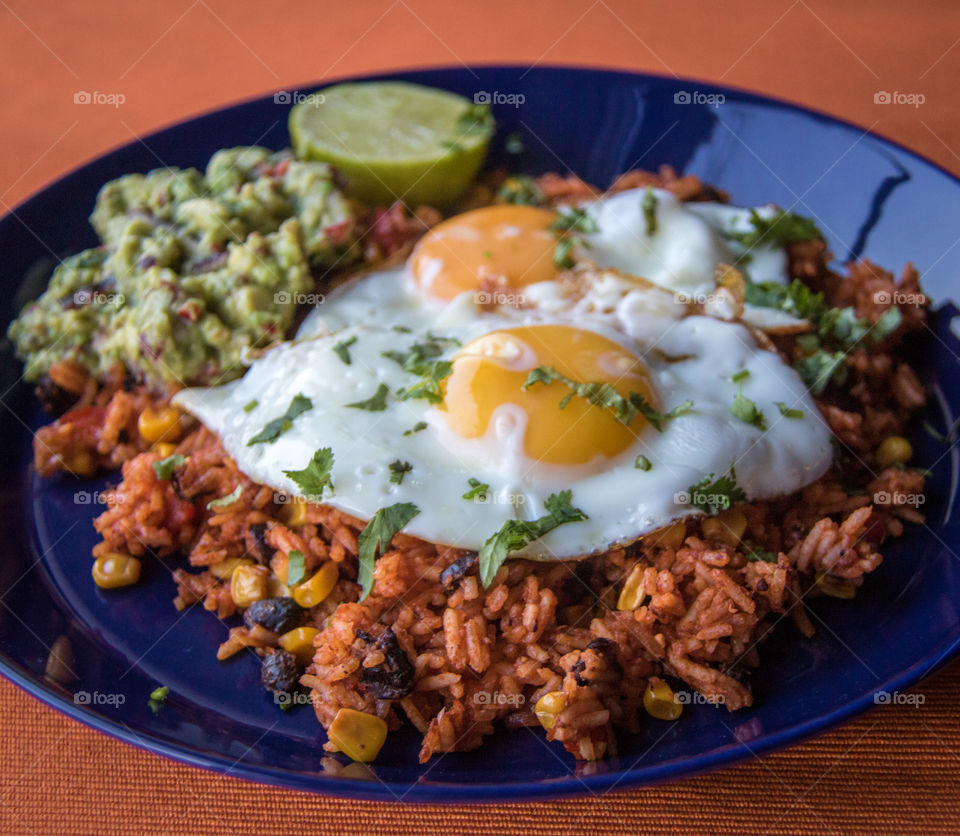 Mexican fried rice with fried eggs and homemade guacamole 