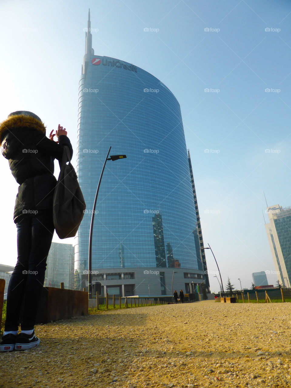 A tourist takes a photo of a tall skyscraper in Milan,Italy