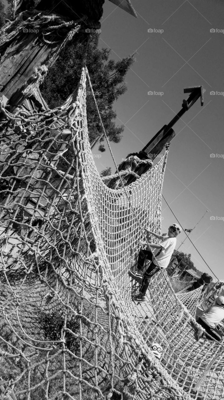 Boy climbing on net in park