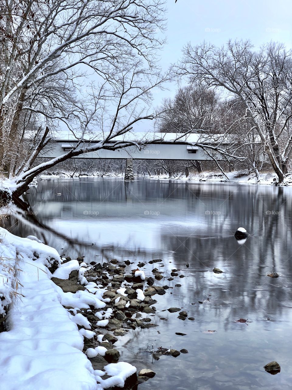 A beautiful view at the old covered bridge on a winters day by the river 