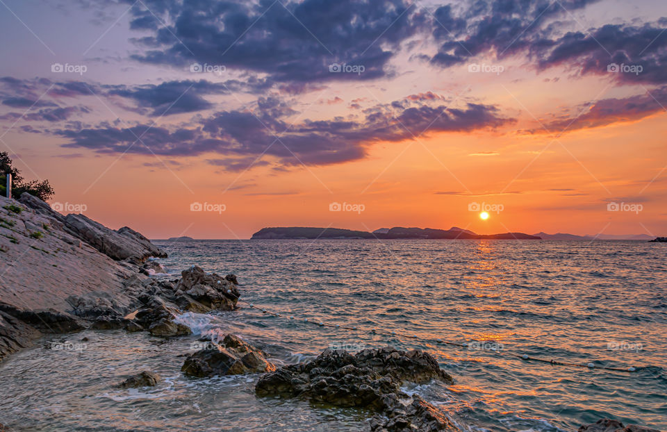 Sunset over rocky beach