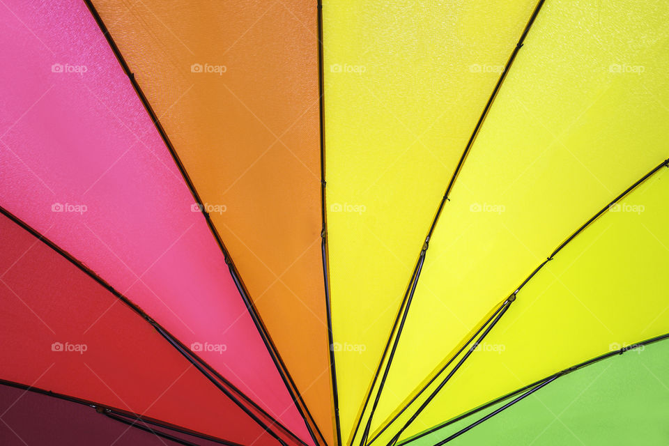Rainbow colored summer umbrella pattern for background