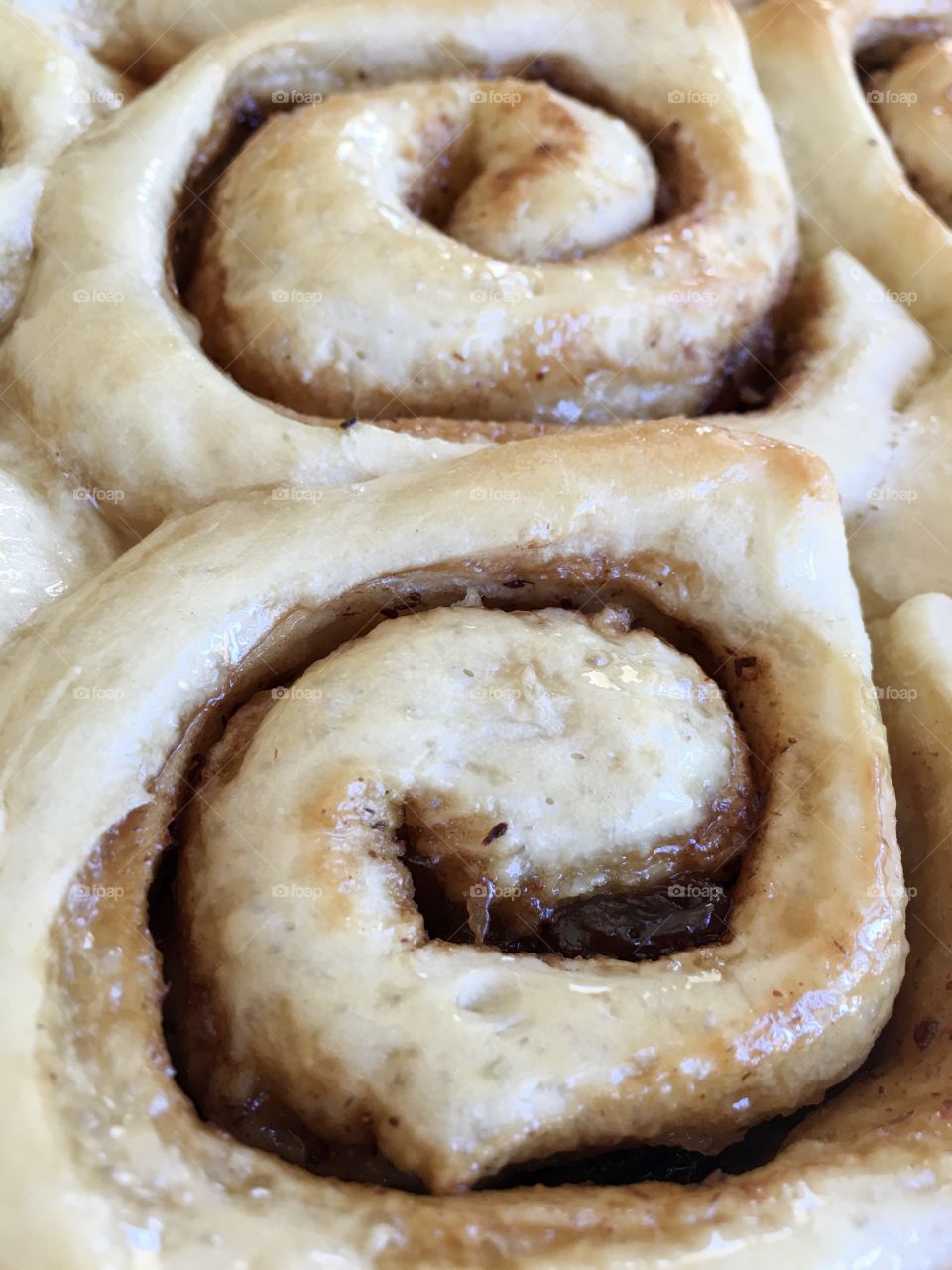 Closeup view fresh baked cinnamon scroll roll with maple syrup glaze