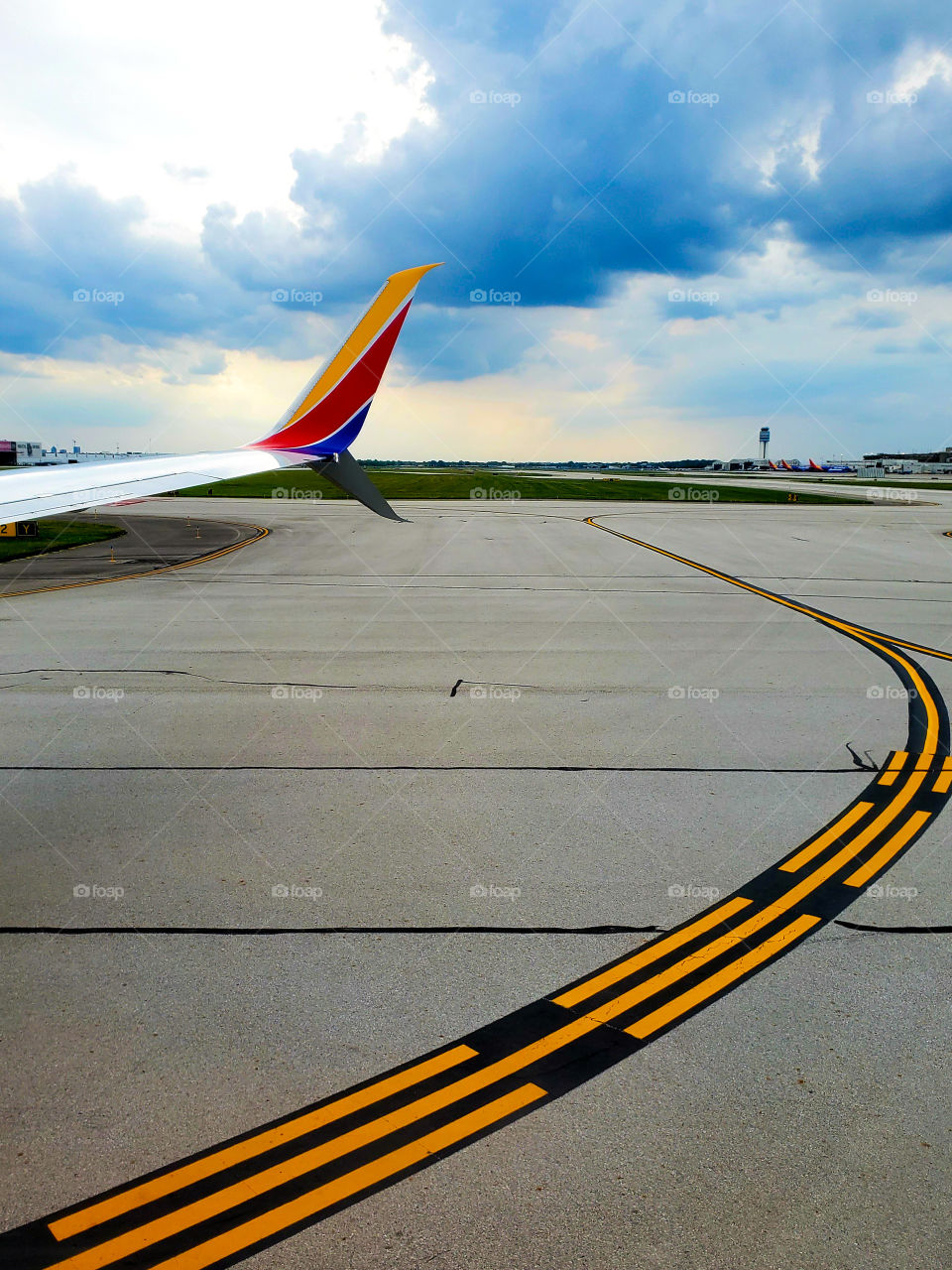 Sitting on a passenger plane about ready to rocket down the runway to take flight into dark skies as a storm moves in