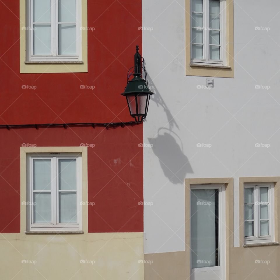 Street lamp on a red and white wall