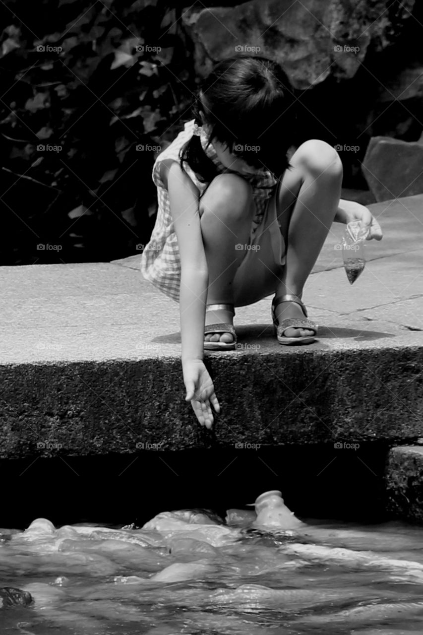 girl feeding koi fishes. A little Chinese girl was feeding the koi fishes at yuyuan garden in Shanghai China.