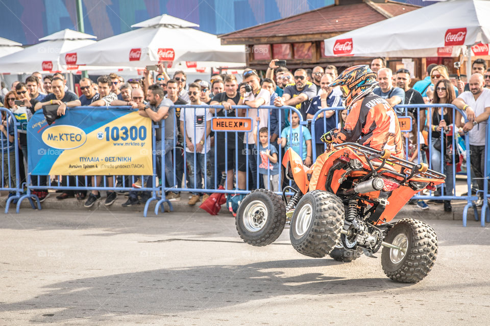 Doing Acrobatics With Quad Bike Terrain Vehicle In Front Of Crowd
