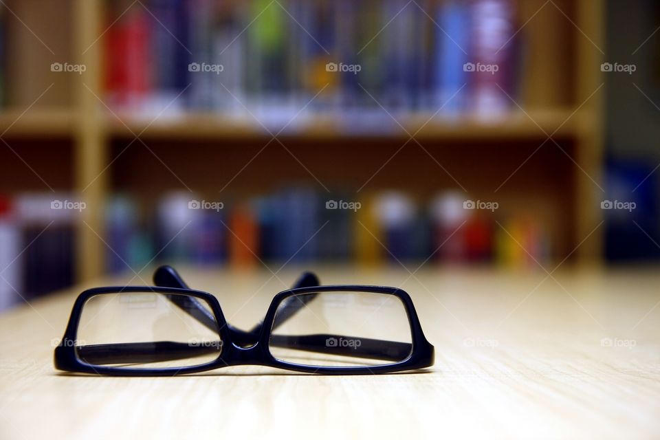 eyeglasses on a table inside a library