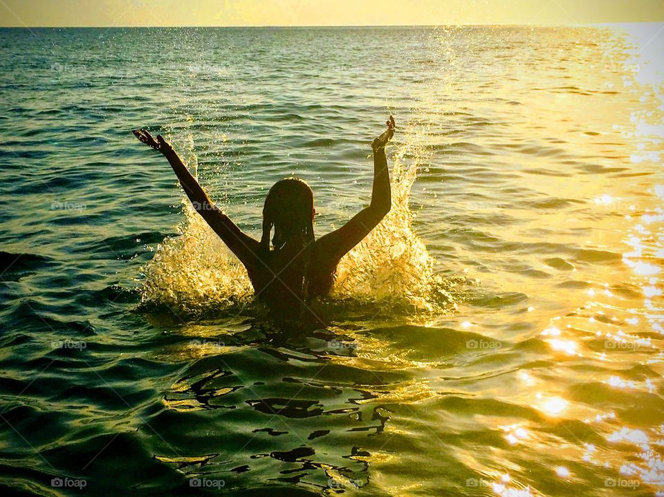 Silhouette of a girl in the sea on a summer day