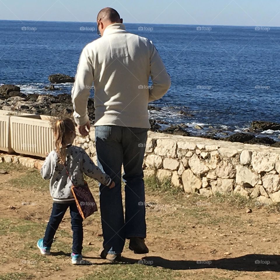 A father and daughter’s walk by the sea.