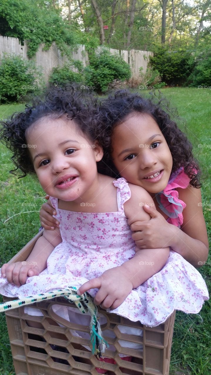 sisters. sisters playing together in a homemade train.