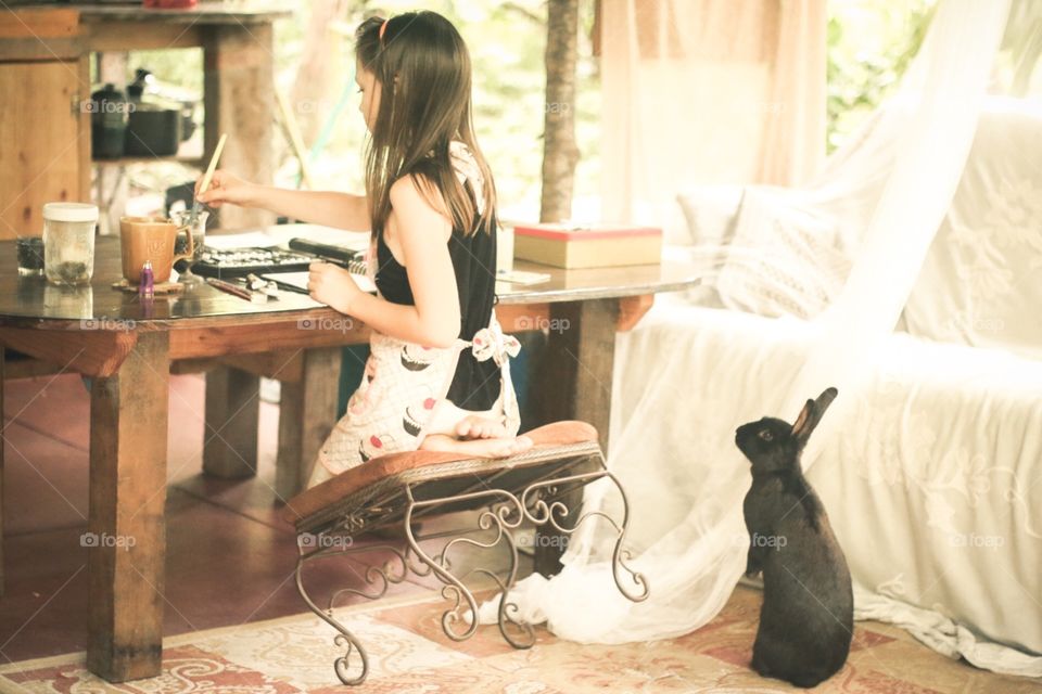 A rabbit is curious about girls drawing
